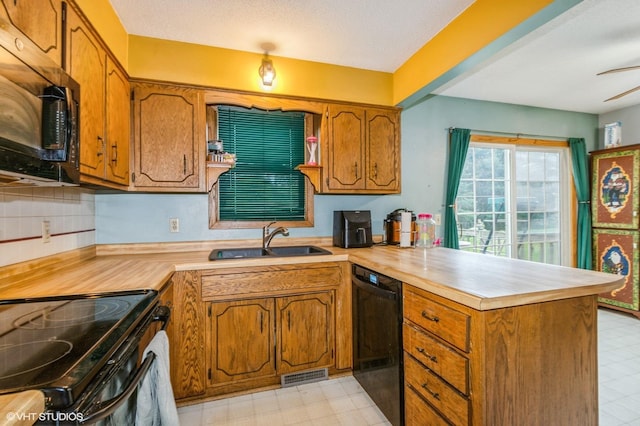 17551 London St NE, Ham Lake, MN 55304 - kitchen featuring black appliances, a peninsula, light floors, a sink, and light countertops