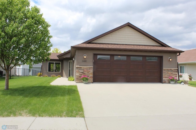 3441 25th St S, Moorhead, MN 56560 - view of front of property featuring stone siding, a shingled roof, concrete driveway, and an attached garage