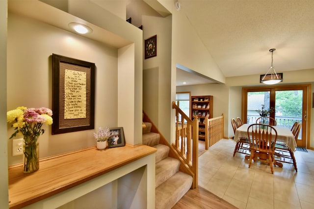 1518 4th Ave N, Sartell, MN 56377 - dining room with stairs, vaulted ceiling, light tile patterned flooring, and a textured ceiling