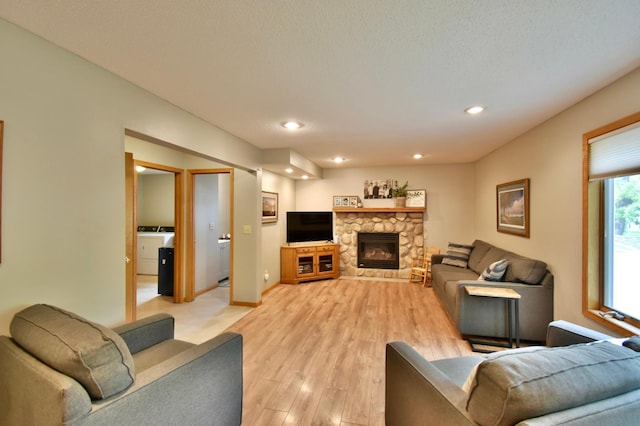 1518 4th Ave N, Sartell, MN 56377 - living area with light wood-style flooring, a stone fireplace, recessed lighting, washer / dryer, and baseboards