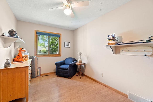 903 Ingalls Rd, Menomonie, WI 54751 - sitting room with light wood-style floors, a ceiling fan, a textured ceiling, and baseboards