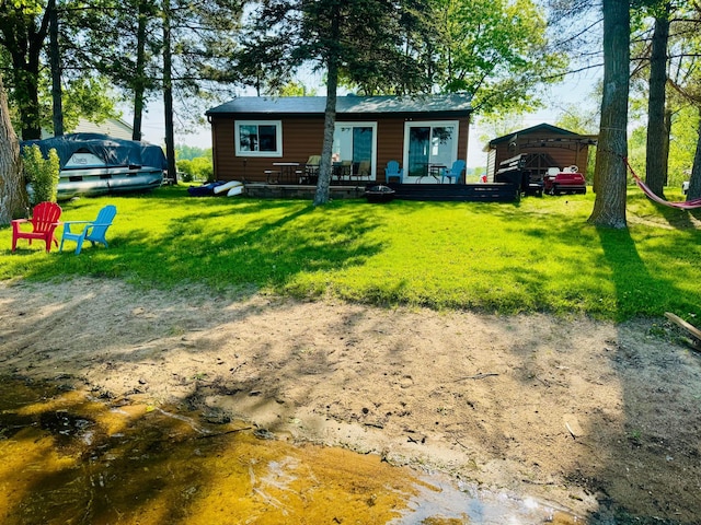 22535 Gateway Dr, Leslie Twp, MN 56360 - back of property featuring a wooden deck, a yard, a carport, and faux log siding