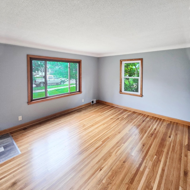 2718 Morgan Ave N, Minneapolis, MN 55411 - empty room with light wood-style floors, a textured ceiling, and baseboards
