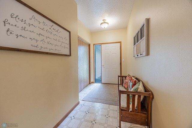 5916 Elm St N, Moorhead, MN 56560 - doorway to outside featuring light floors, baseboards, and a textured ceiling