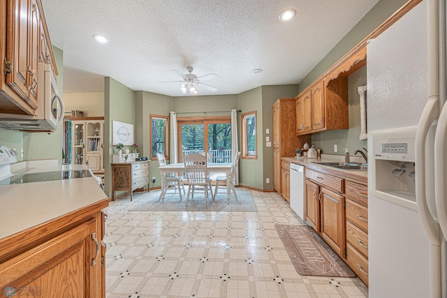 5916 Elm St N, Moorhead, MN 56560 - kitchen with white appliances, a sink, a ceiling fan, a textured ceiling, and light countertops
