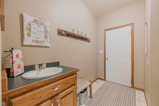 5916 Elm St N, Moorhead, MN 56560 - bathroom with vanity, a textured ceiling, and baseboards