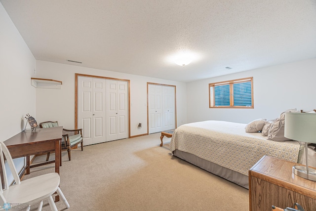 5916 Elm St N, Moorhead, MN 56560 - bedroom featuring multiple closets, light colored carpet, and a textured ceiling