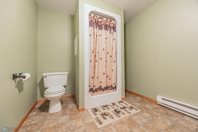 5916 Elm St N, Moorhead, MN 56560 - bathroom featuring a textured ceiling, toilet, baseboard heating, stone tile floors, and baseboards