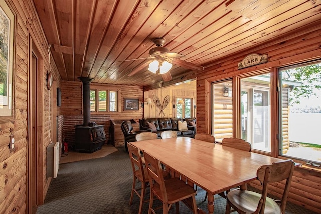 1378 Sunflower Trl NE, Outing, MN 56662 - carpeted dining area with wooden ceiling, a wood stove, ceiling fan, and rustic walls