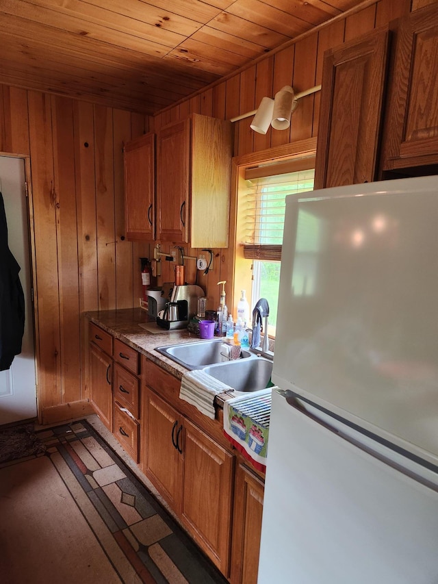 35270 Bear Creek Rd, Partridge Twp, MN 55704 - kitchen with freestanding refrigerator, wooden ceiling, a sink, wood walls, and brown cabinetry