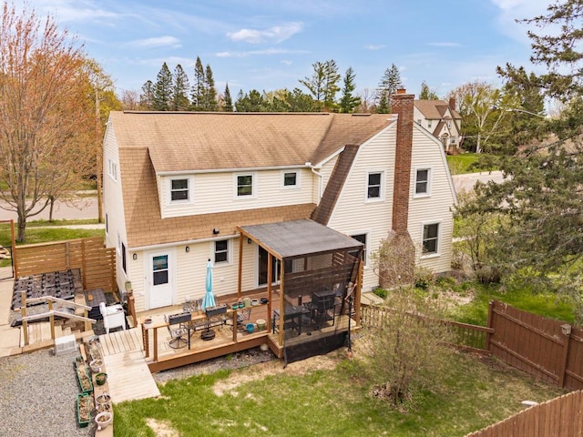 4031 Regent St, Duluth, MN 55804 - rear view of house with a wooden deck, a gambrel roof, a shingled roof, a chimney, and a sunroom