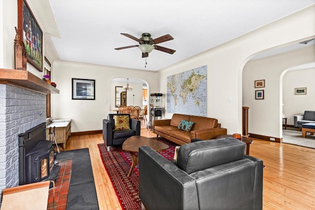 4031 Regent St, Duluth, MN 55804 - living room featuring arched walkways, a ceiling fan, hardwood / wood-style flooring, baseboards, and a wood stove