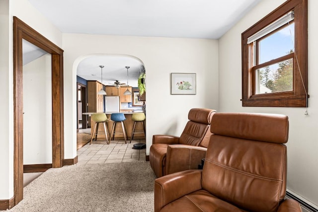 4031 Regent St, Duluth, MN 55804 - living room with a baseboard radiator, baseboards, light colored carpet, light tile patterned floors, and arched walkways