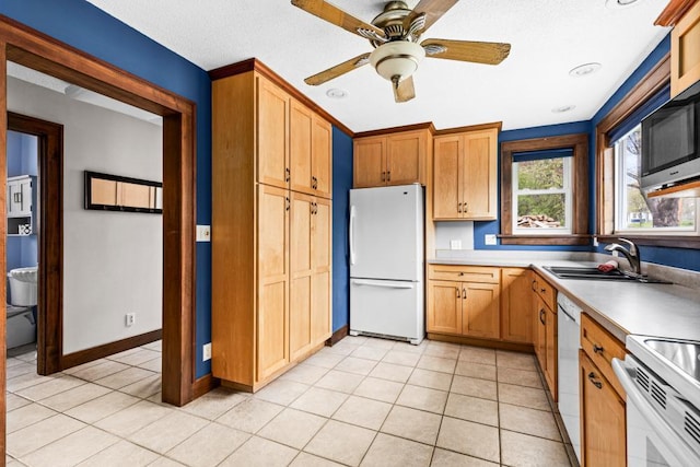 4031 Regent St, Duluth, MN 55804 - kitchen with white appliances, a sink, light countertops, light tile patterned floors, and ceiling fan