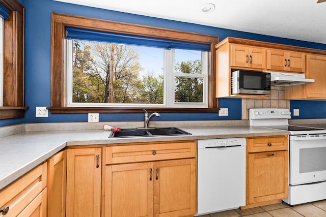 4031 Regent St, Duluth, MN 55804 - kitchen featuring white appliances, a sink, under cabinet range hood, light tile patterned floors, and decorative backsplash