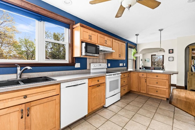 4031 Regent St, Duluth, MN 55804 - kitchen with white appliances, a sink, light tile patterned floors, under cabinet range hood, and a peninsula