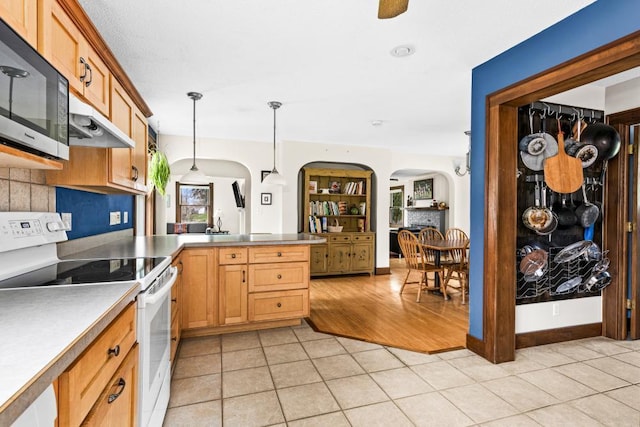 4031 Regent St, Duluth, MN 55804 - kitchen featuring white range with electric cooktop, arched walkways, a peninsula, light tile patterned flooring, and decorative light fixtures