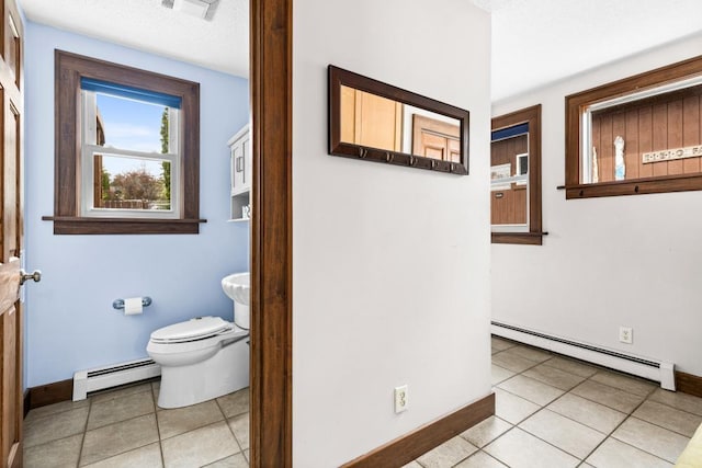 4031 Regent St, Duluth, MN 55804 - bathroom with a baseboard radiator, tile patterned flooring, toilet, and baseboards