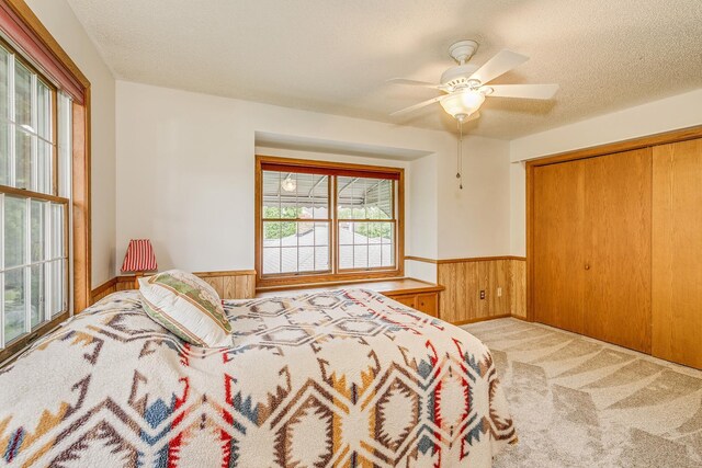 2816 29th Ave NE, Saint Anthony, MN 55418 - bedroom with wainscoting, wood walls, carpet flooring, a closet, and a ceiling fan