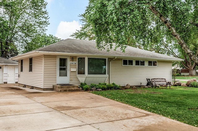 5404 Welcome Ave N, Crystal, MN 55429 - view of front facade featuring a front yard, concrete driveway, a shingled roof, and a garage