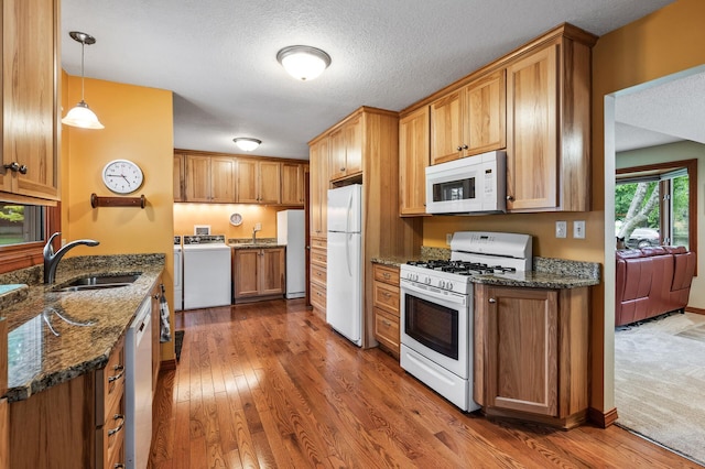 5404 Welcome Ave N, Crystal, MN 55429 - kitchen with white appliances, a sink, dark wood finished floors, dark stone countertops, and brown cabinets