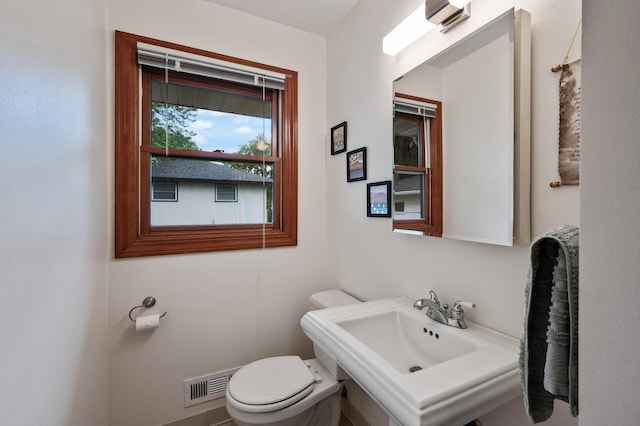 5404 Welcome Ave N, Crystal, MN 55429 - half bathroom featuring toilet, a wall unit AC, and a sink