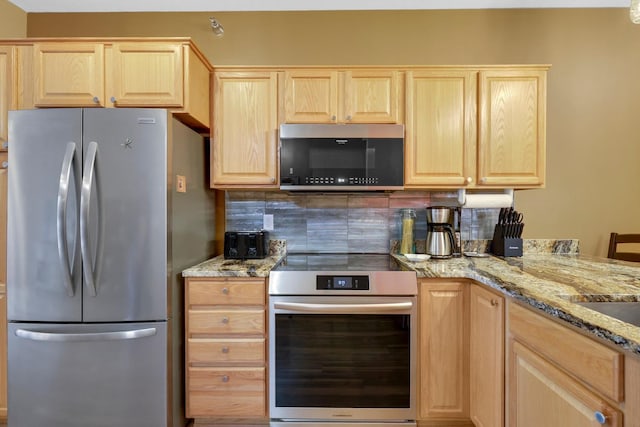 16154 Main Ave SE # 120, Prior Lake, MN 55372 - kitchen with stainless steel appliances, light brown cabinetry, decorative backsplash, and light stone counters