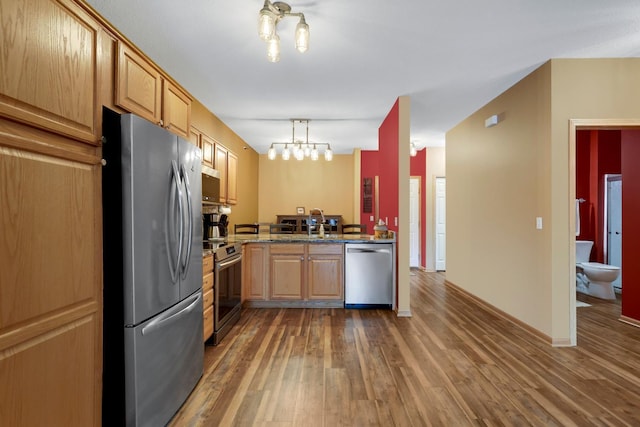16154 Main Ave SE # 120, Prior Lake, MN 55372 - kitchen with appliances with stainless steel finishes, hardwood / wood-style flooring, a chandelier, stone counters, and baseboards