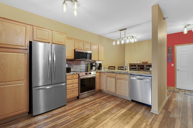 16154 Main Ave SE # 120, Prior Lake, MN 55372 - kitchen featuring appliances with stainless steel finishes, light brown cabinets, wood finished floors, and decorative backsplash