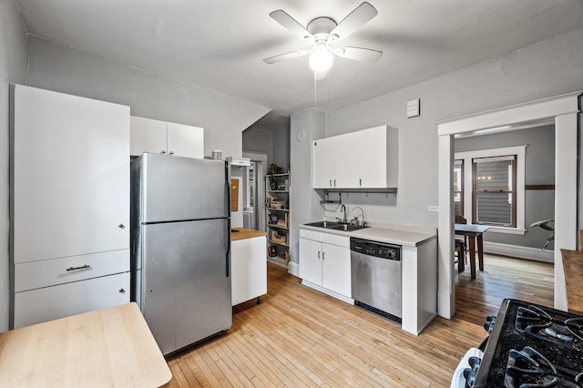 4312 Nokomis Ave, Minneapolis, MN 55406 - kitchen with stainless steel appliances, light wood-style floors, ceiling fan, and white cabinetry