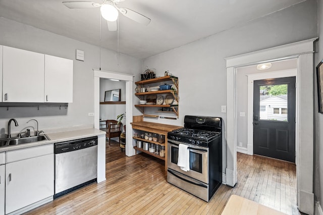4312 Nokomis Ave, Minneapolis, MN 55406 - kitchen with appliances with stainless steel finishes, a sink, light countertops, light wood-style floors, and white cabinetry