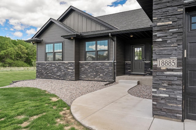 18885 Poppy St NW, Oak Grove, MN 55303 - view of front facade with stone siding, board and batten siding, a front lawn, and a shingled roof
