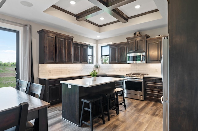 18885 Poppy St NW, Oak Grove, MN 55303 - kitchen featuring appliances with stainless steel finishes, coffered ceiling, a kitchen island, light countertops, and decorative backsplash