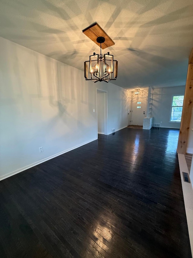 123 Birchridge Dr, Brainerd, MN 56401 - unfurnished dining area featuring a chandelier, dark wood-type flooring, baseboards, and a textured ceiling