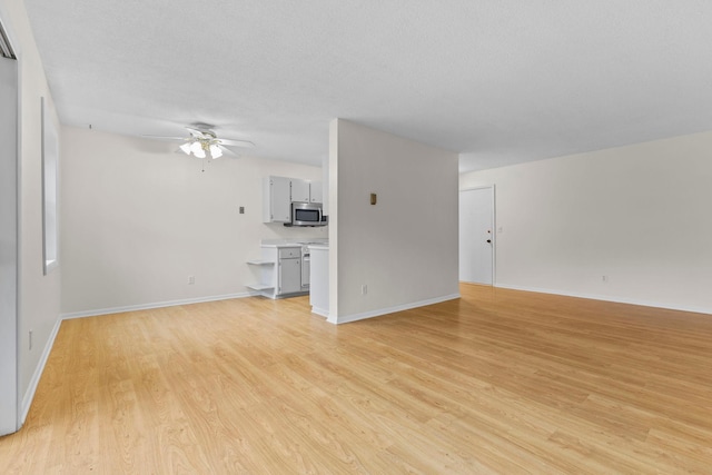 10113 34th St Unit 105, Minnetonka, MN 55305 - unfurnished living room featuring ceiling fan, light wood-style floors, and baseboards