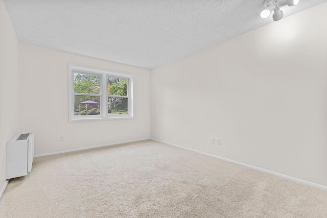 10113 34th St Unit 105, Minnetonka, MN 55305 - empty room featuring carpet floors, radiator heating unit, baseboards, and a textured ceiling