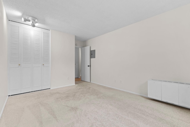 10113 34th St Unit 105, Minnetonka, MN 55305 - unfurnished bedroom with carpet flooring, baseboards, a textured ceiling, radiator, and electric panel