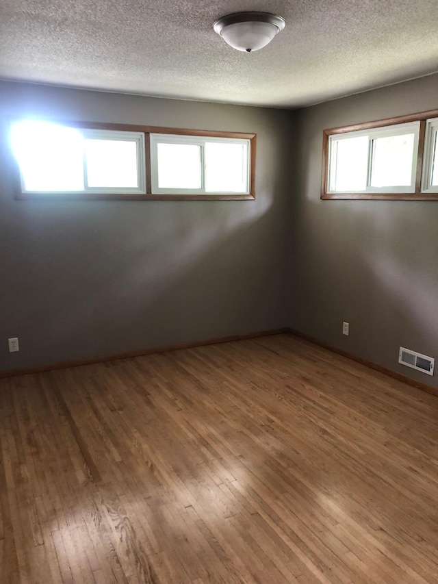 1304 13th Ave N, Moorhead, MN 56560 - empty room featuring a textured ceiling and wood finished floors