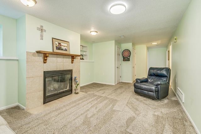 1357 64th Ave NE, Fridley, MN 55432 - living room featuring a textured ceiling, a tiled fireplace, carpet floors, and built in shelves