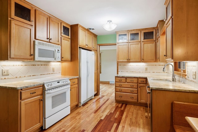 4932 Cedar Ave S, Minneapolis, MN 55417 - kitchen featuring white appliances, tasteful backsplash, light wood-type flooring, light stone countertops, and glass insert cabinets