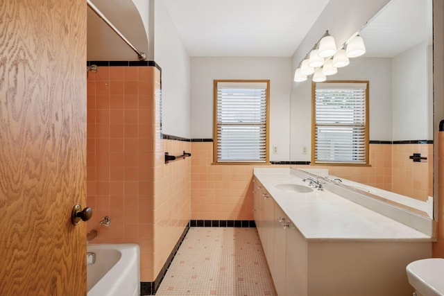 4932 Cedar Ave S, Minneapolis, MN 55417 - bathroom with tile walls, a wainscoted wall, vanity, and shower / tub combination