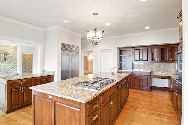 2645 Arcola Ln, Minnetonka Beach, MN 55391 - kitchen with stainless steel appliances, a chandelier, an island with sink, light wood-type flooring, and decorative backsplash