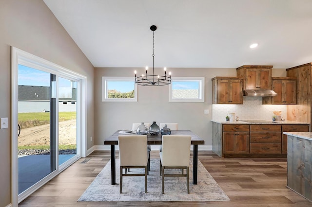 10014 177th Ave NW, Elk River, MN 55330 - dining space with a chandelier, light wood finished floors, recessed lighting, vaulted ceiling, and baseboards