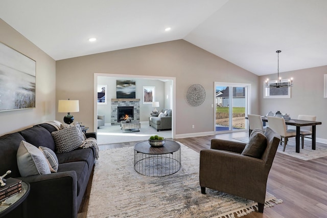 10014 177th Ave NW, Elk River, MN 55330 - living room featuring a chandelier, wood finished floors, vaulted ceiling, a fireplace, and baseboards