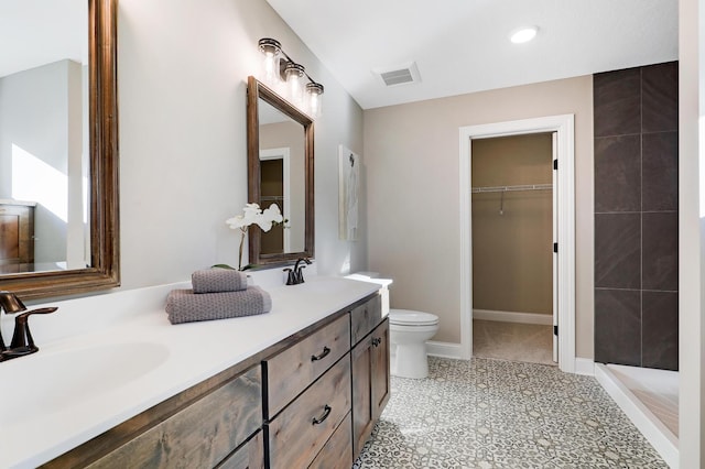 10014 177th Ave NW, Elk River, MN 55330 - bathroom featuring double vanity, toilet, recessed lighting, a spacious closet, and a tile shower