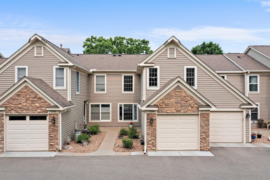 7290 Penny Hill Rd, Eden Prairie, MN 55346 - view of front of property featuring stone siding, driveway, and an attached garage