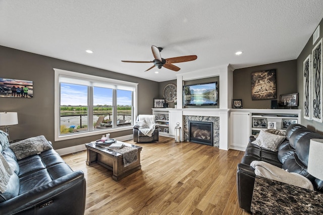 26042 Sunset Dr, Chisago City, MN 55013 - living room with ceiling fan, light wood-style floors, a high end fireplace, recessed lighting, and a textured ceiling