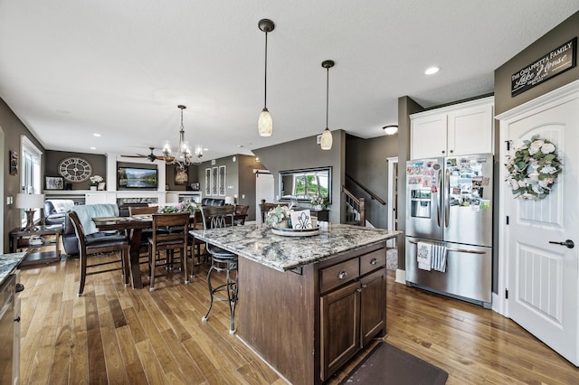 26042 Sunset Dr, Chisago City, MN 55013 - kitchen with appliances with stainless steel finishes, wood-type flooring, light stone counters, a kitchen bar, and recessed lighting