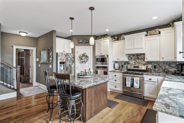 26042 Sunset Dr, Chisago City, MN 55013 - kitchen featuring stainless steel appliances, light wood-type flooring, a kitchen island, white cabinets, and recessed lighting