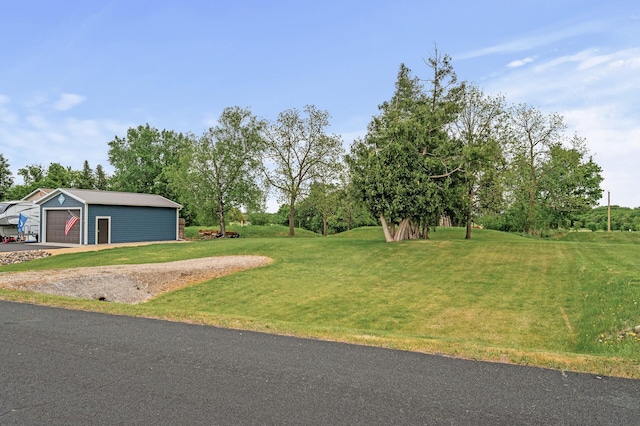 26042 Sunset Dr, Chisago City, MN 55013 - view of green lawn featuring an outbuilding, a garage, and view of wooded area